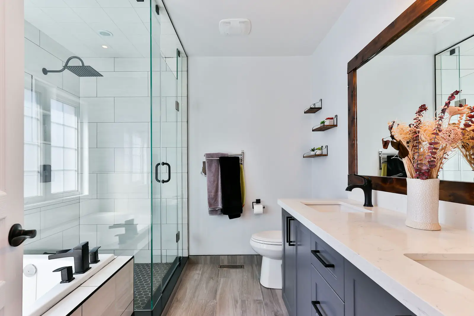 A bathroom with a glass shower and a double vanity. Shown on the homepage for Arlington, TX.